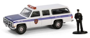 GREEN97160-D - GMC Suburban 2500 1985 Police mit Figur aus der Serie THE HOBBY SHOP in Blisterverpackung